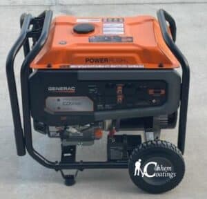 This image shows an orange and black Generac portable generator with wheels and a handle, featuring PowerRush technology, against a concrete background.